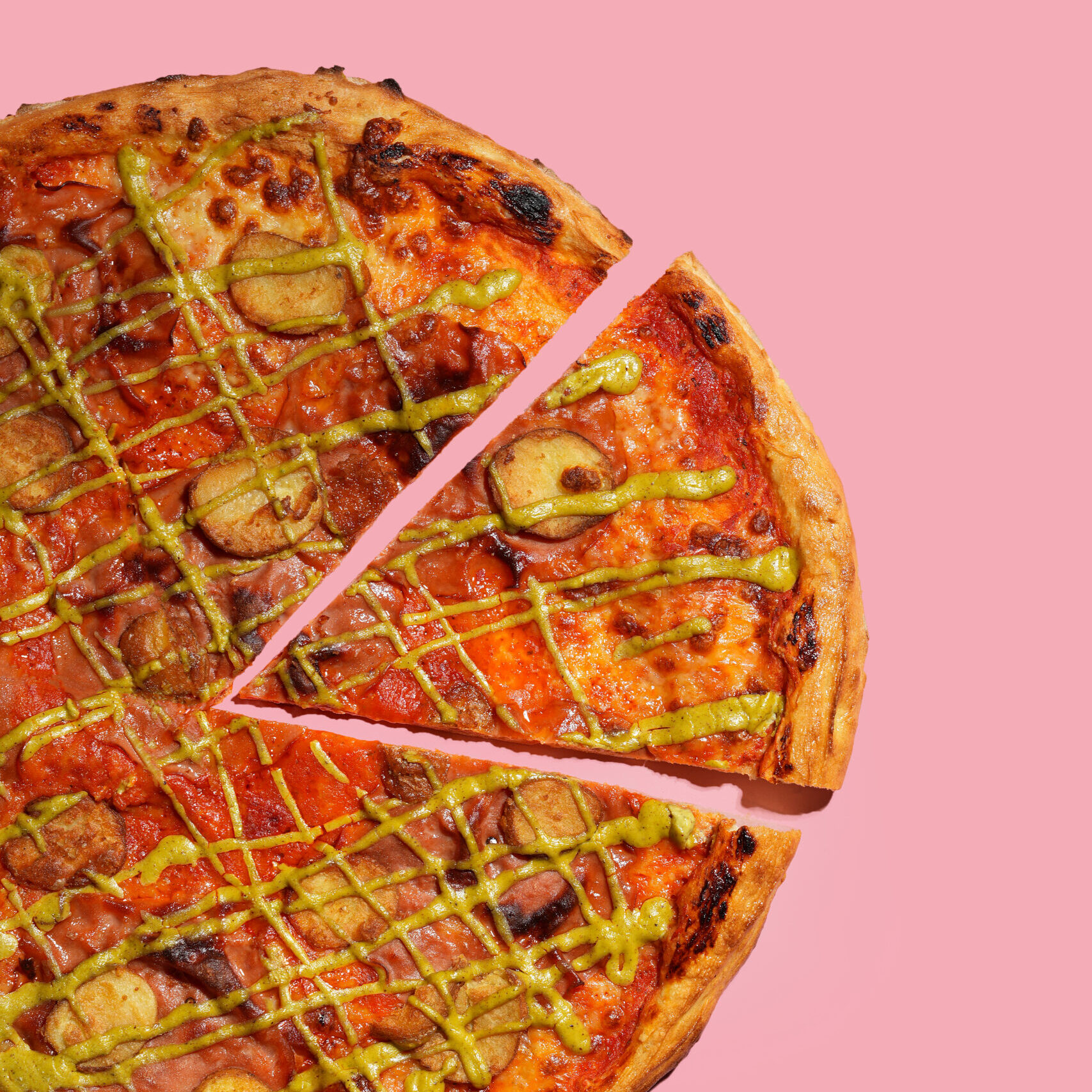 20 inch mortadella pizza with a slice cut on a pink background