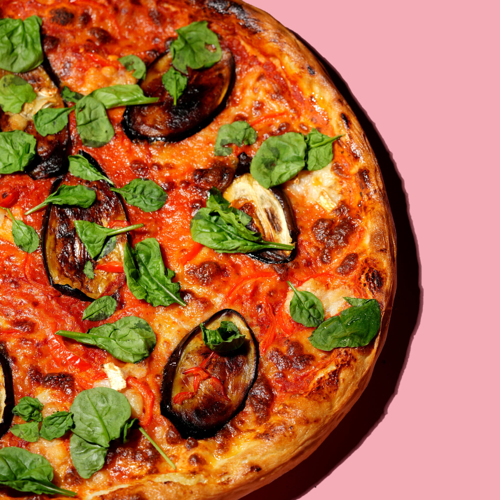 20 inch aubergine pizza on a pink background