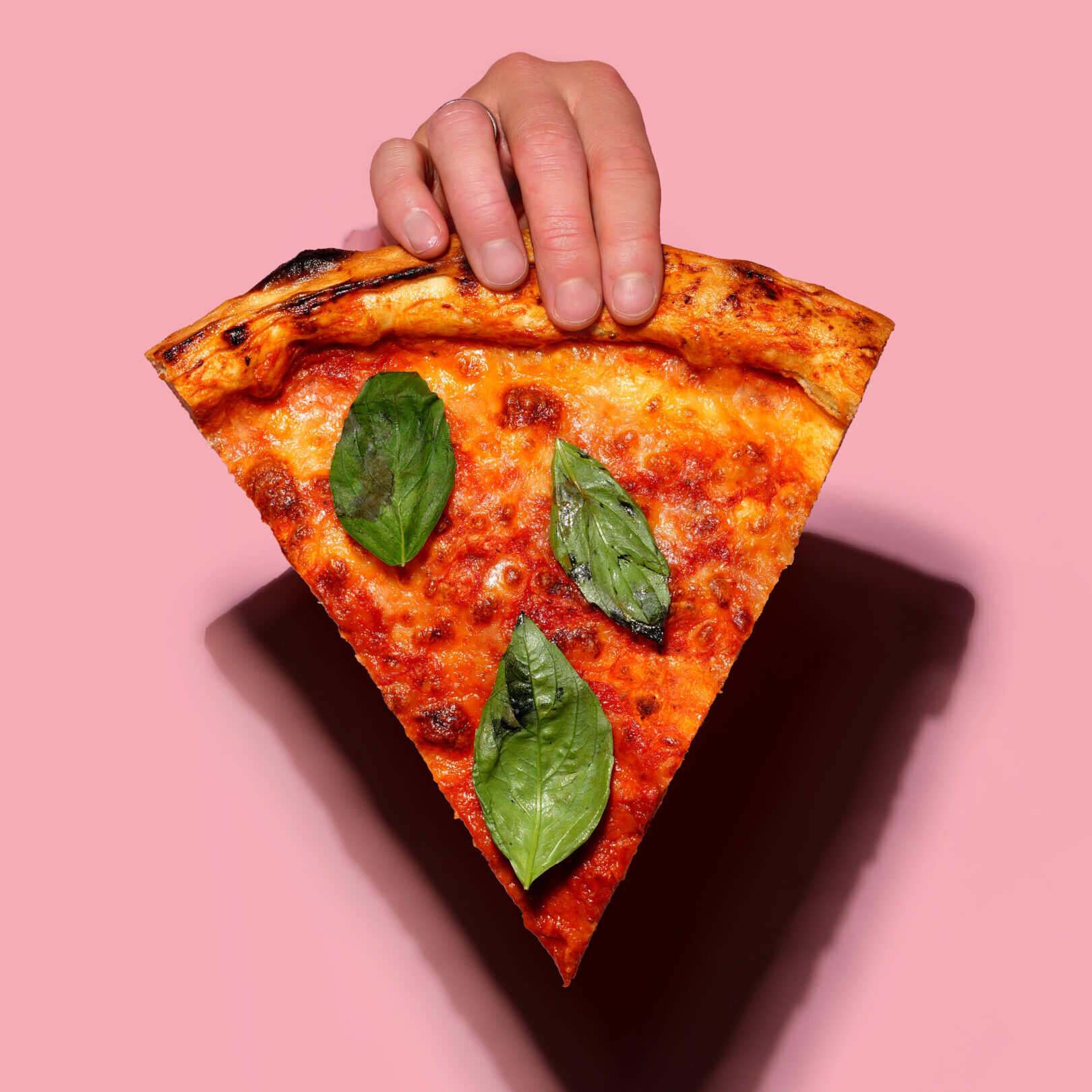 hand holding a slice of Margherita pizza